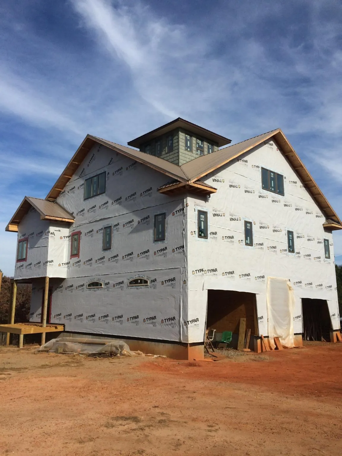 New two story house under construction with a cupola and gabled roofs in Manor
